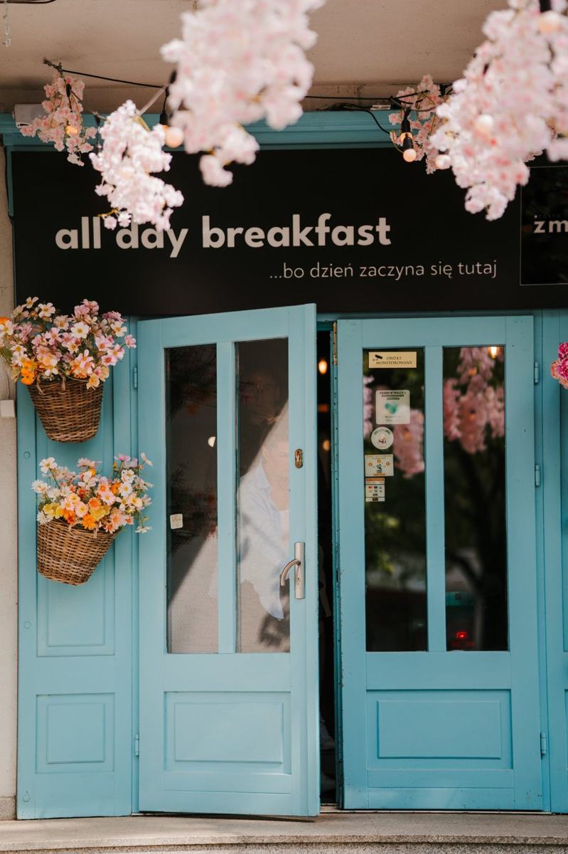 Niebieskie drzwi młynka z szyldem all day breakfast